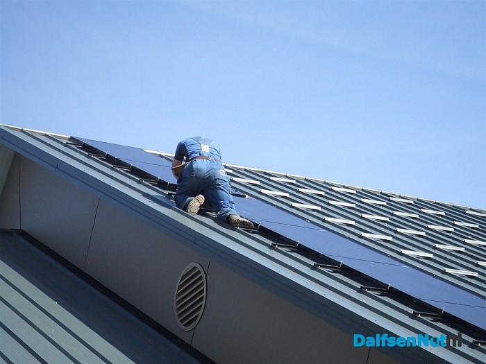 Dijkman bezig met het leggen van zonnepanelen