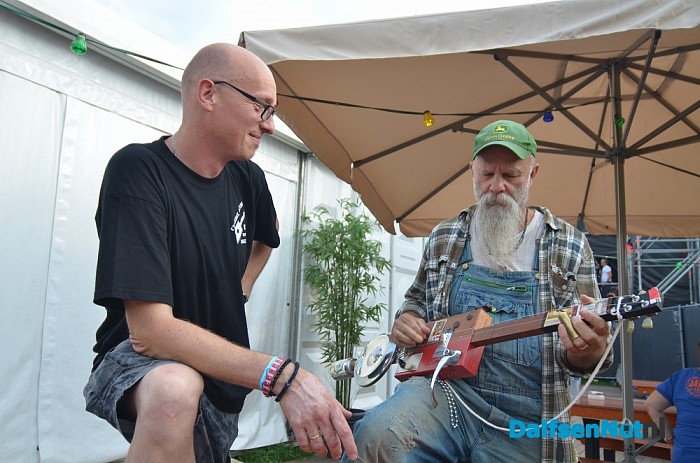 Cigarbox Henri overhandigt gitaar op Zwarte Cross - Foto: Johan Bokma