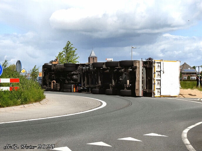 Truck met oplegger op zijn kant
