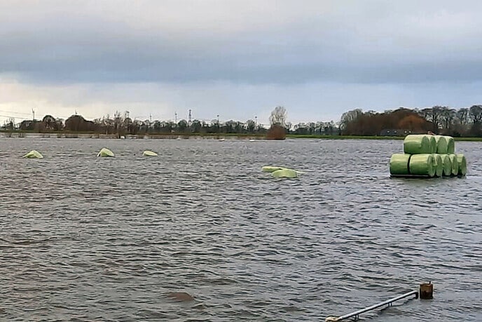 Platte wagen met hooibalen aan de wandel.