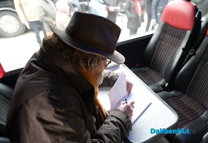 Bussjeffeur Grotenhuis reikt zijn eerste boek uit aan buschauffeur Teeven - Foto: Johan Bokma